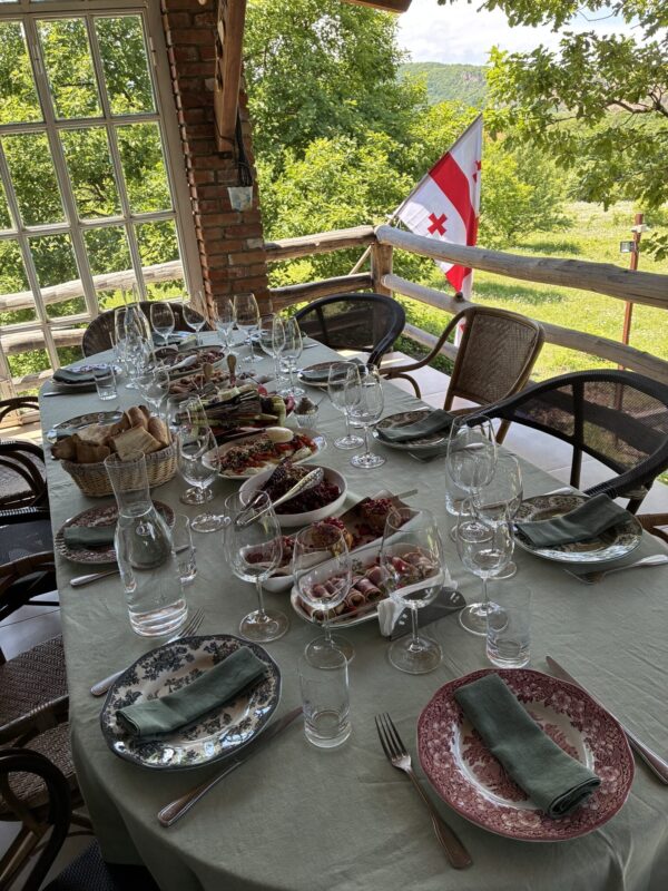 A table set for a supra, the Georgian flag waving patriotically.